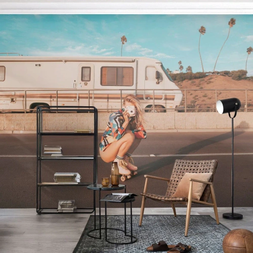 Papier Peint Photo Premium Sand - Une fille en patins à roulettes avec un appareil photo devant un camping-car - 100x70cm - Souriez s'il-vous-plait! - Décoration murale moderne pour le salon et la chambre ARTTOR