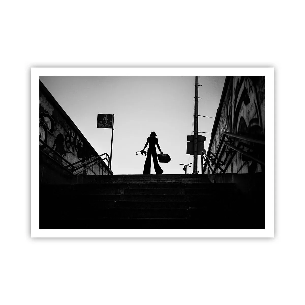 Affiche - Poster - Une figure de femme dans les escaliers en noir et blanc avec une atmosphère dynamique - 100x70cm - Pèlerinage urbain - Décoration murale moderne pour le salon et la chambre ARTTOR