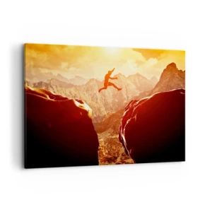 Impression sur toile - Image sur toile - Une silhouette sautant entre des rochers avec des montagnes en arrière-plan - 100x70cm - Dépassement des limites - Décoration murale moderne pour le salon et la chambre ARTTOR