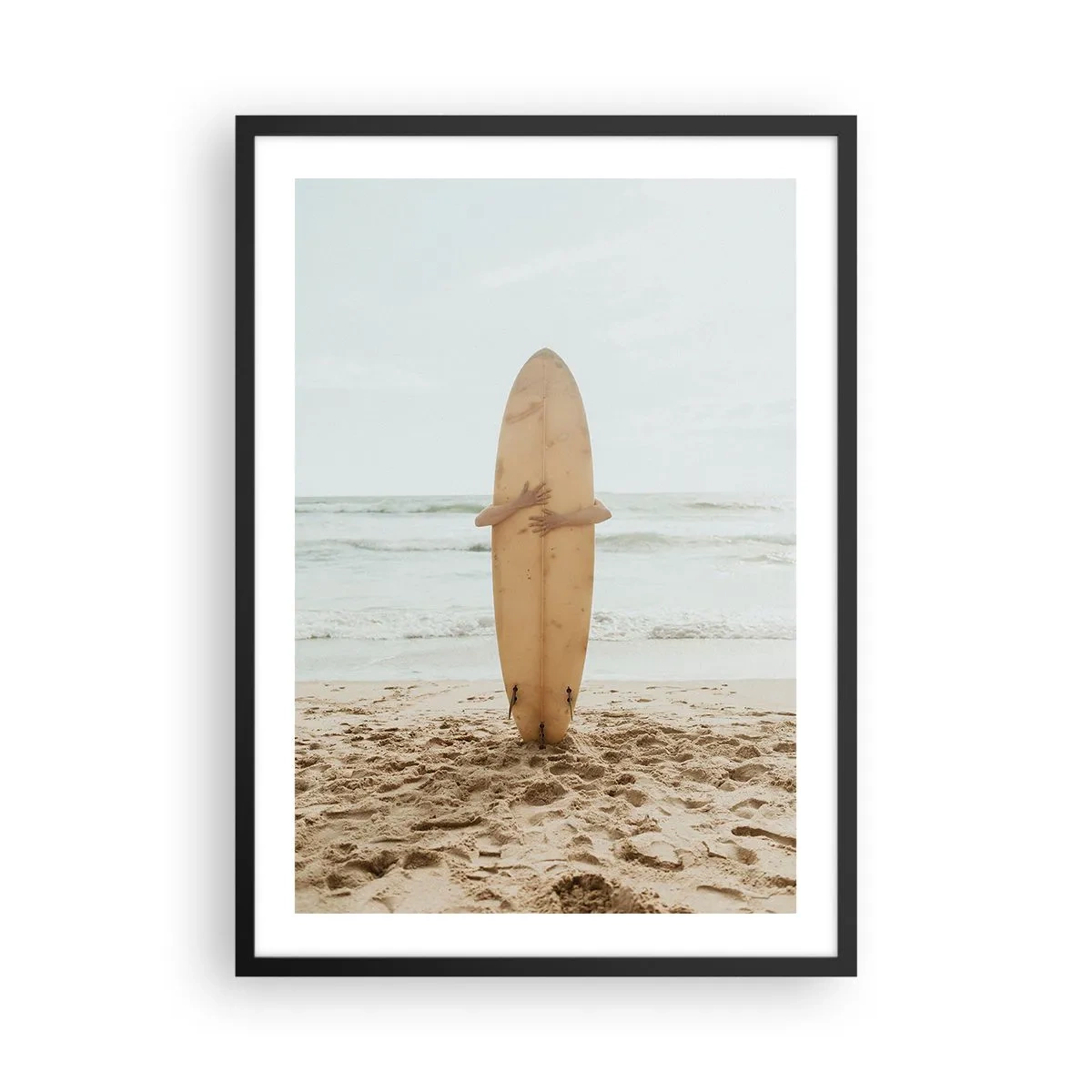 Affiche dans un cadre noir - Poster - Une personne tenant une planche de surf sur une plage, avec vue sur la mer. - 50x70cm - Pour l'amour des vagues - Décoration murale moderne pour le salon et la chambre ARTTOR