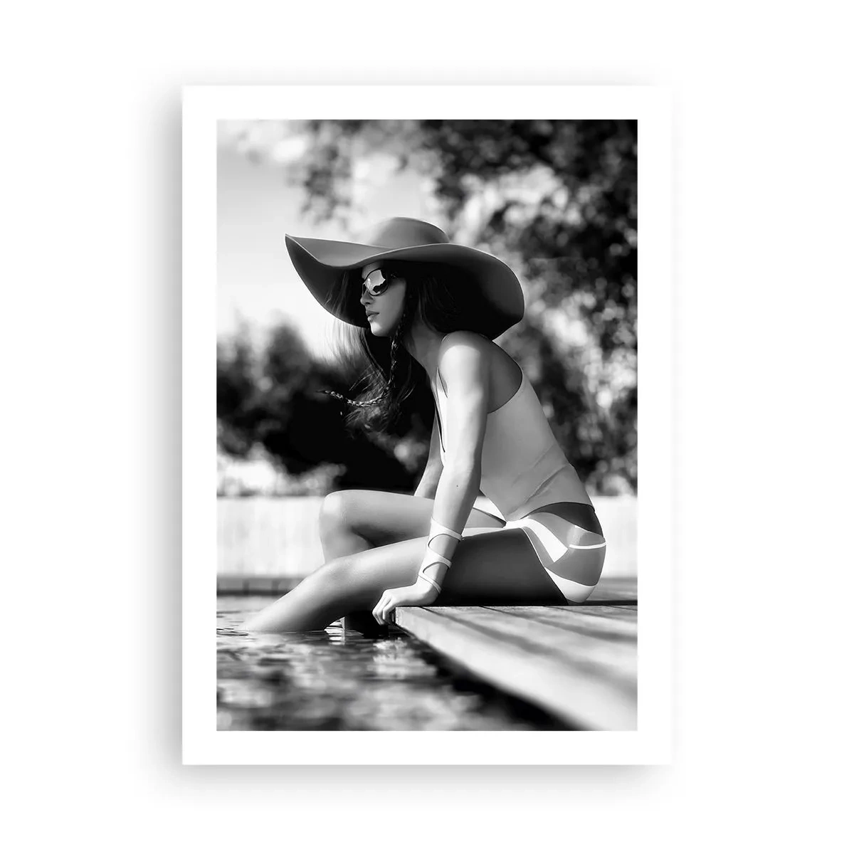 Affiche - Poster - Une photographie en noir et blanc d'une femme portant un chapeau assise au bord de l'eau. - 50x70cm - Rêve d'été - Décoration murale moderne pour le salon et la chambre ARTTOR