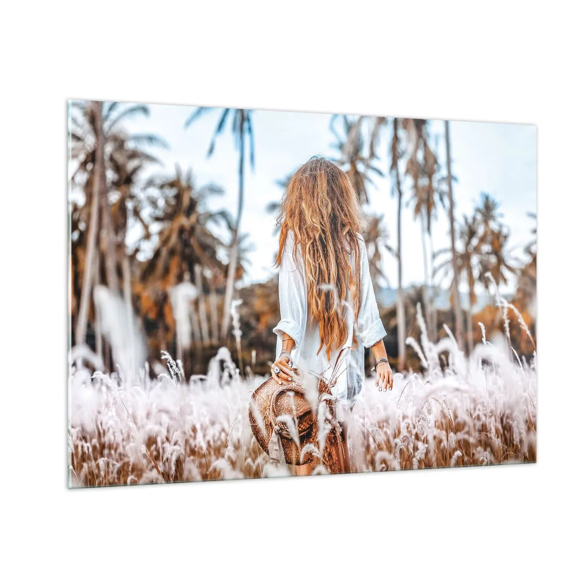 Impression sur verre - Image sur verre - Une femme dans l'herbe avec un chapeau à la main sur fond de palmiers - 100x70cm - Né de peluches d'herbe - Décoration murale moderne pour le salon et la chambre ARTTOR